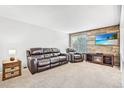 Comfortable living room with a cozy seating arrangement, wood accent wall, and a window at 9630 W 104Th Ave, Broomfield, CO 80021
