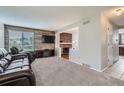 Cozy living room with a wood accent wall, fireplace, and plush carpet at 9630 W 104Th Ave, Broomfield, CO 80021