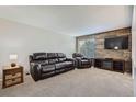 Comfortable living room with carpet, leather sofa set, and a TV stand at 9630 W 104Th Ave, Broomfield, CO 80021