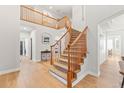 Elegant foyer with wood floors and a graceful staircase leading to the second floor at 7463 Soapstone Way, Castle Rock, CO 80108