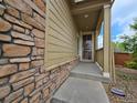 Covered porch with stone detail and space for chairs at 483 W 172Nd Pl, Broomfield, CO 80023