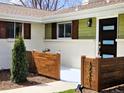 Close-up of modern front door and address with wooden feature wall at 3281 Vivian Dr, Wheat Ridge, CO 80033