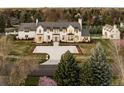 Stunning aerial view of a white mansion with manicured lawns, mature trees, and circular driveway at 20 Viking Dr, Cherry Hills Village, CO 80113
