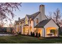 Expansive home exterior features a covered porch, multiple gables, and lush lawn at 20 Viking Dr, Cherry Hills Village, CO 80113