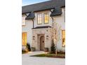 Close-up of front door with stone trim, planter boxes, and a well manicured yard at 20 Viking Dr, Cherry Hills Village, CO 80113