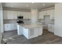 Spacious kitchen features white cabinets, stainless steel appliances, and a large center island with quartz countertop at 17719 Prairie Peak Trl, Parker, CO 80134