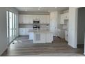 Bright kitchen with white cabinets, stainless steel appliances, a center island with a quartz countertop, and sliding glass doors at 17719 Prairie Peak Trl, Parker, CO 80134