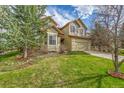 Two-story home with manicured lawn, landscaping, mature trees, and an attached two-car garage at 18142 E Oakwood Pl, Aurora, CO 80016