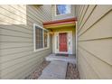 Inviting front entry featuring a red front door, sidelight windows, and rock landscaping at 18142 E Oakwood Pl, Aurora, CO 80016