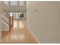 Bright hallway with hardwood floors, staircase, and natural light from large windows at 18142 E Oakwood Pl, Aurora, CO 80016