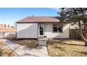 Charming single-story home with a well-maintained lawn, walkway, and mature tree on a sunny day at 972 S Zeno Way, Aurora, CO 80017