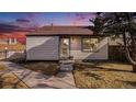 Charming single-story home at dusk featuring walkway and mature tree under a vibrant sky at 972 S Zeno Way, Aurora, CO 80017