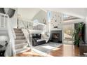 Bright living room featuring vaulted ceilings, a stone fireplace, and open staircase at 972 S Zeno Way, Aurora, CO 80017