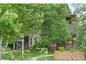 Multi-level townhouse with landscaped front yard featuring healthy plants and a brick-lined garden area at 4544 Utica St, Denver, CO 80212
