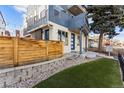Stylish home showcasing a mix of wood and siding accents, complemented by rock landscaping and vibrant green artificial turf at 1259 Perry St, Denver, CO 80204