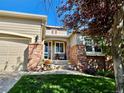 Inviting home entrance with brick accents, a cozy seating area, and a well-maintained lawn at 1033 Bramblewood Dr, Castle Pines, CO 80108