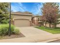 Single Gathering home with attached garage, manicured lawn, and mature trees at 1033 Bramblewood Dr, Castle Pines, CO 80108