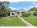 Adorable one-story home with manicured lawn, trimmed shrubbery, and an inviting walkway at 1909 Iola St, Aurora, CO 80010