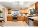 Traditional kitchen with wooden cabinets, tile floors, and lots of natural light at 4210 S Fox St, Englewood, CO 80110