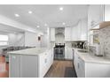 Open kitchen showcasing modern white cabinetry, stainless steel appliances, and a kitchen island at 23 S Nome St # A, Aurora, CO 80012