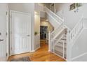Bright foyer featuring an open staircase with white banisters, hardwood flooring, and a view into the adjacent living area at 10155 Riverstone Dr, Parker, CO 80134