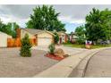 Charming home featuring a well-manicured front yard, a two-car garage, and a brick chimney at 8217 Club Crest Dr, Arvada, CO 80005