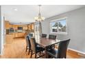 Bright dining area featuring wood floors, chandelier, and a large window overlooking the backyard at 1206 Baldwin Park Cir, Castle Rock, CO 80104