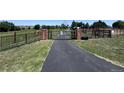 Long paved driveway leading through a gated entrance, ensuring privacy and security at 17450 E 14Th Dr, Aurora, CO 80011