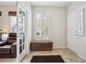 Inviting foyer featuring tile flooring, a storage bench by a bright window, and a view into the adjacent living space at 6617 S Reed Way # C, Littleton, CO 80123