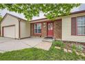 Charming home with a brick entryway, colorful front door, and a lush green lawn at 18240 E Mexico Pl, Aurora, CO 80017