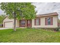 Inviting home with an attached garage, large front lawn and a mature tree providing shade at 18240 E Mexico Pl, Aurora, CO 80017