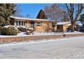 Brick ranch home with attached garage and a snow-covered front yard at 1000 Collyer St, Longmont, CO 80501