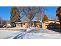 Ranch home with attached garage and a snow-covered front yard at 1000 Collyer St, Longmont, CO 80501