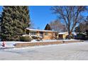 Ranch style home with a landscaped yard, partially covered in snow at 1000 Collyer St, Longmont, CO 80501