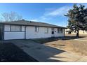 Charming single-story home with a classic white exterior, well-maintained lawn, and a spacious driveway at 4785 Estes St, Wheat Ridge, CO 80033