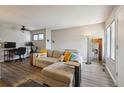 Bright living room featuring hardwood floors, a ceiling fan, and a comfortable couch with colorful throw pillows at 1830 Newland Ct # 101, Lakewood, CO 80214