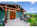 Stunning exterior with a covered porch, dining area, beautiful wood trim, and mountain views at 6565 Marshmerry Ln, Evergreen, CO 80439