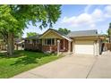 Well-maintained brick home with an attached garage and long driveway at 470 S Queen St, Lakewood, CO 80226