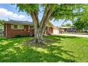 Brick home with a beautiful, shady yard and attached garage in a residential neighborhood at 470 S Queen St, Lakewood, CO 80226