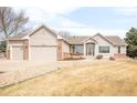 Well-manicured lawn complements this home, boasting a three-car garage and appealing curb appeal at 14850 Akron St, Brighton, CO 80602