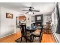 Cozy dining room featuring a black brick fireplace, hardwood floors, and an open view to the kitchen at 2612 Meadowbrook Dr, Denver, CO 80221
