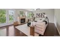 Bright living room featuring a fireplace, hardwood floors, and access to an outdoor patio at 2230 Valentia St, Denver, CO 80238