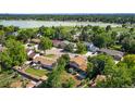 Aerial view of neighborhood with mature trees, and a park and lake in the distance at 6411 W 82Nd Dr, Arvada, CO 80003