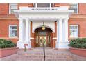 Elegant entrance to building with ornate wood doors, white columns, and 