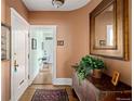 Inviting hallway with hardwood floors, decorative mirror, and access to other rooms at 836 E 17Th Ave # 2B, Denver, CO 80218