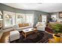 Bright living room featuring hardwood floors, neutral furniture, and large windows with plantation shutters at 836 E 17Th Ave # 2B, Denver, CO 80218