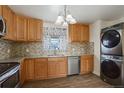 Bright kitchen features wood cabinets, granite countertops, stainless steel appliances, and stacked washer/dryer at 41 Cortez St, Denver, CO 80221