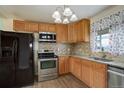 Well-lit kitchen showcases wood cabinets, granite countertops, and stainless steel refrigerator and oven at 41 Cortez St, Denver, CO 80221