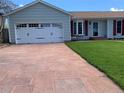 Well-maintained home featuring an attached garage and a stone driveway, surrounded by a lush green lawn at 16308 E Wyoming Dr, Aurora, CO 80017