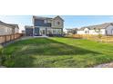 Large backyard with grassy area, wooden fence, and patio at 16198 E 111Th Pl, Commerce City, CO 80022
